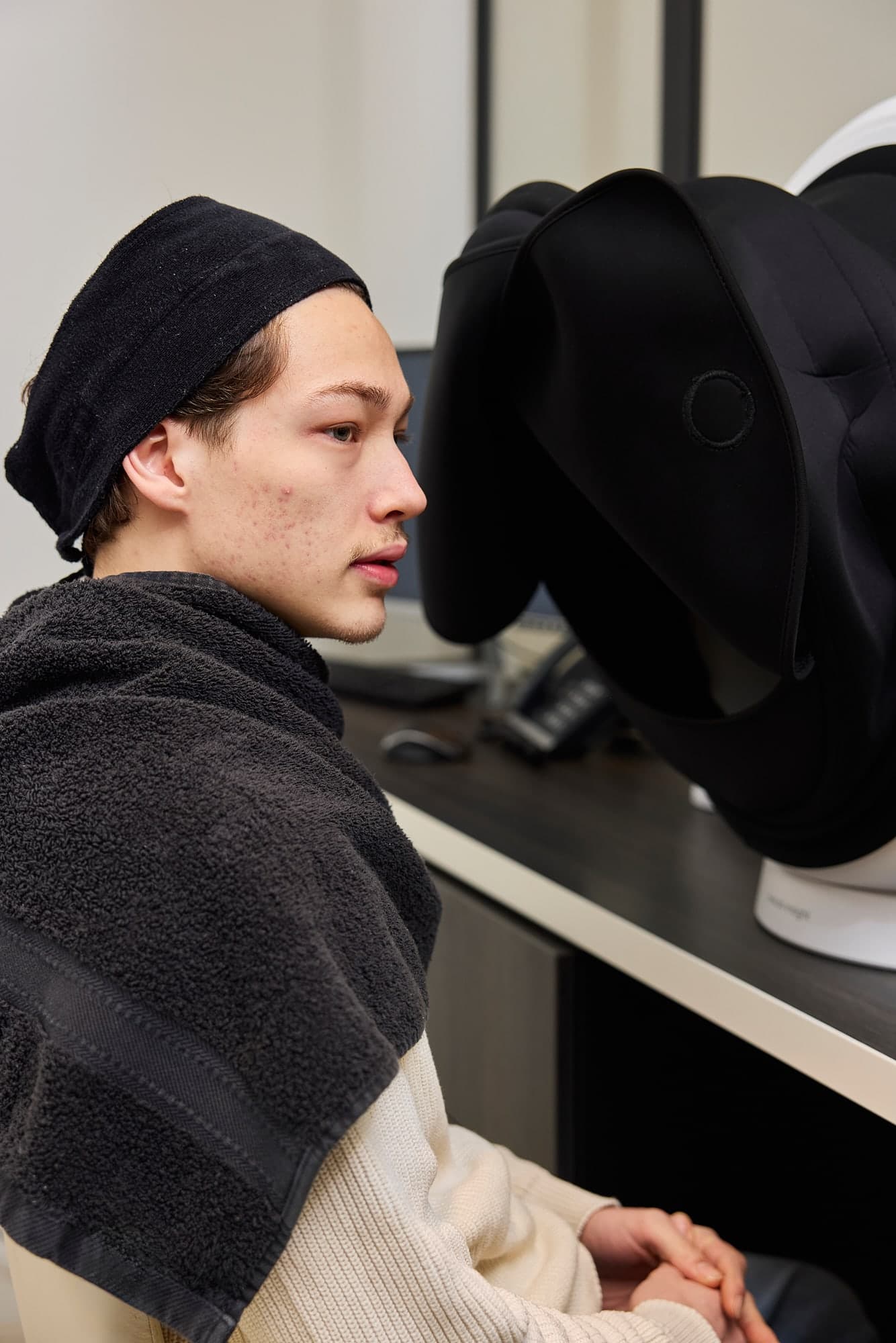 Cliënt zit voor de huidscanner in de kliniek, klaar voor een meting