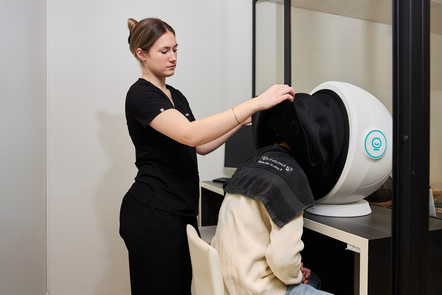 Behandelaar plaatst een cliënt in de EVE-M huidscanner