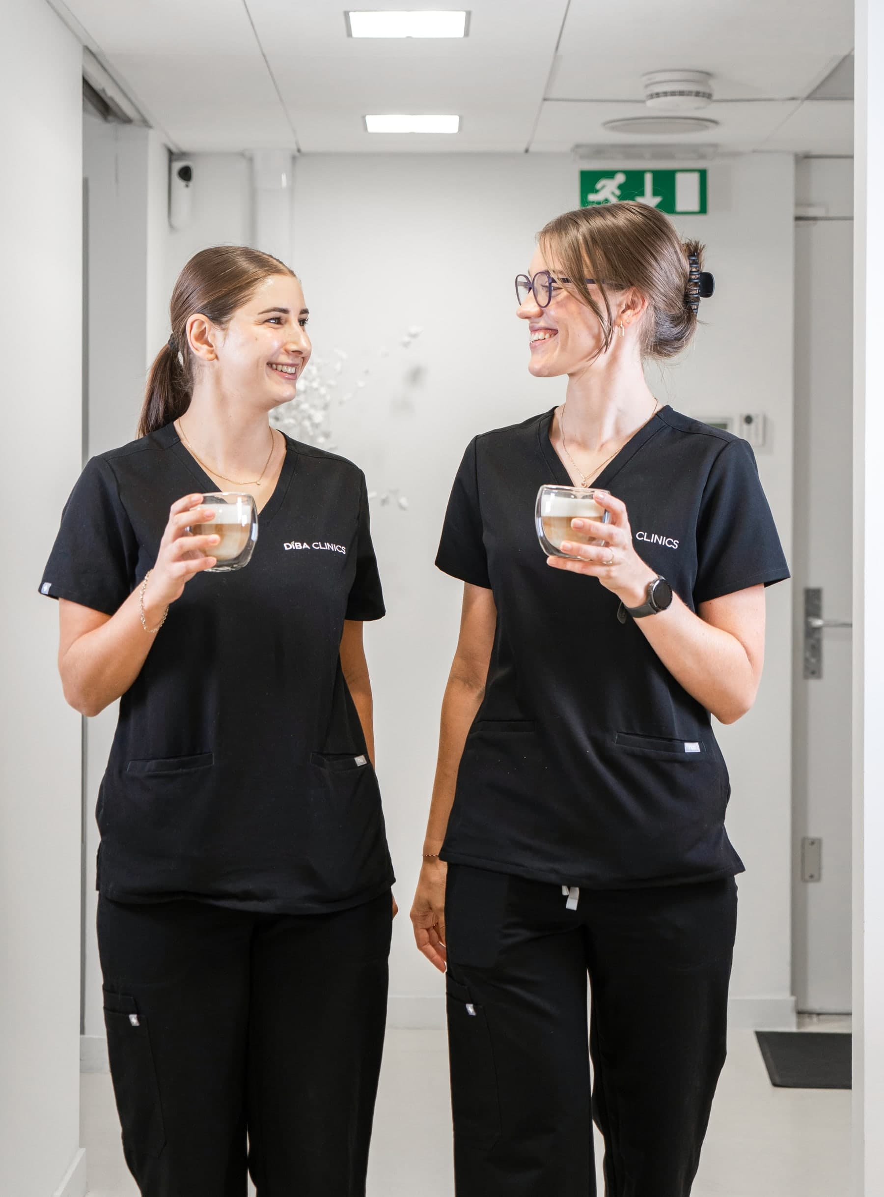 Twee behandelaars van Diba Clinics met koffie in de gang van de kliniek